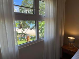 uma janela num quarto com vista para a praia em Panorama Guesthouse Apartments Beau Vallon Beach em Beau Vallon