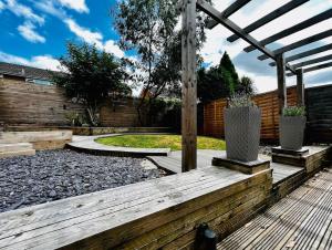 a garden with a wooden deck and a pergola at Entire Modern House in Tamworth - 2 Double Beds + Free Parking in Tamworth