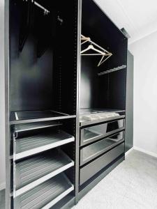 a black closet with empty shelves in a room at Entire Modern House in Tamworth - 2 Double Beds + Free Parking in Tamworth