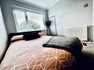 a bedroom with a large bed in front of a window at Entire Modern House in Tamworth - 2 Double Beds + Free Parking in Tamworth