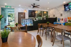 un restaurant avec des tables et des chaises en bois dans l'établissement Villa Renai Resort, à Bentong