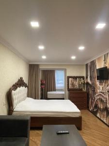 ein Schlafzimmer mit einem großen Bett und einem Sofa in der Unterkunft HASI hotel Jermuk in Dschermuk