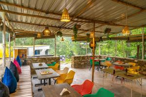 an outdoor restaurant with tables and chairs and lights at Whoopers Boutique Resort Jibhi in Jibhi