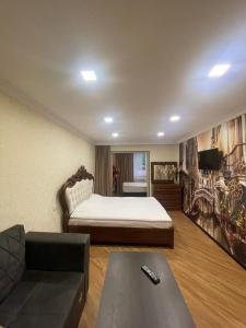 ein Wohnzimmer mit einem Bett und einem Sofa in der Unterkunft HASI hotel Jermuk in Dschermuk