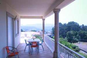 porche con mesa y sillas en el balcón en cerca do casal en Santo Tirso