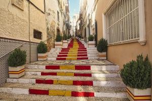 una alfombra de escaleras con pintura roja y amarilla en Villa Inia - PlusHolidays, en Calpe