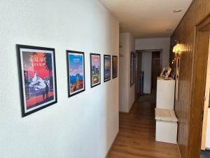 un couloir avec une rangée de photos sur un mur dans l'établissement Appartement de vacances - ski-in ski-out, à Veysonnaz