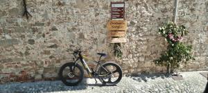 un vélo garé à côté d'un mur de briques avec un panneau dans l'établissement Corte dei Molini, à Faedis