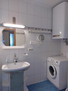 La salle de bains est pourvue d'un lave-linge et d'un lavabo. dans l'établissement Idyllische Vorstadtwohnung mit direktem Parkblick, 