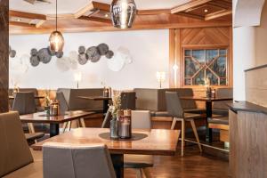 a dining room with wooden tables and chairs at Hotel Victoria in Ischgl