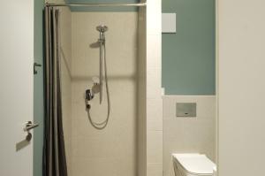 a shower with a glass door next to a toilet at VB Boutique Apartment - Studio in belebtem Viertel nah zur Messe in Frankfurt/Main