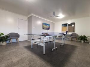 a ping pong table in an office with two chairs at Y Motels Kingaroy in Kingaroy