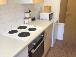a small kitchen with a stove and a microwave at Cool and cosy in Brandon