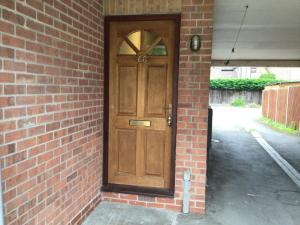een houten deur aan de zijkant van een bakstenen gebouw bij Cool and cosy in Brandon