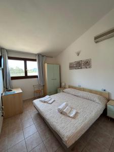 a bedroom with a bed with two towels on it at La Corte Degli Ulivi in Cardedu +50 photos