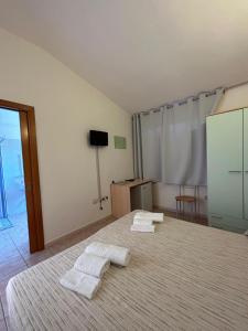 a bedroom with two white towels on a bed at La Corte Degli Ulivi in Cardedu