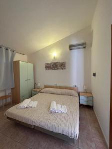 a bedroom with a bed with two towels on it at La Corte Degli Ulivi in Cardedu