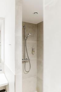 a shower with a shower head in a bathroom at i - PARK Hotel Klingholz in Reichenberg