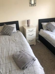 a bedroom with two beds and a night stand at 8 Pickering Road in Telford
