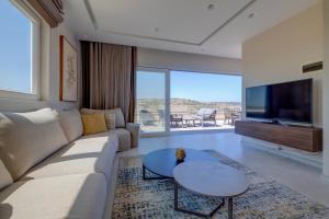 a living room with a couch and a tv at Lux Penthouse Valley Views Hot Tub in Siggiewi in Siġġiewi