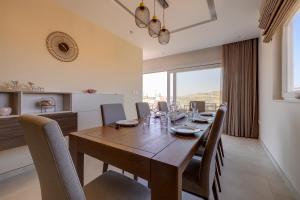 a dining room with a wooden table and chairs at Lux Penthouse Valley Views Hot Tub in Siggiewi in Siġġiewi