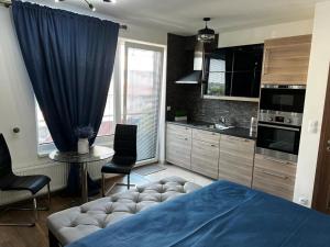 sypialnia z niebieskim łóżkiem i kuchnią w obiekcie Apartment IRON CUBE w Pradze