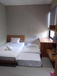 two beds in a small room with a window at M Pavilion - BSD in Serpong