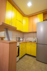 a kitchen with yellow cabinets and a refrigerator at Lorono Kosta in Belgrade