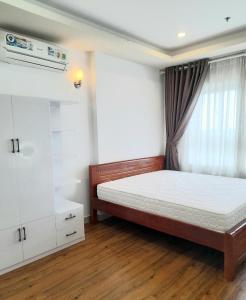 ein Schlafzimmer mit einem großen Bett und einem Fenster in der Unterkunft Chung cư TDC Plaza in Hòa Lợi (2)
