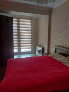 a bedroom with a large red bed with a window at ELSAR guesthouse in Osh
