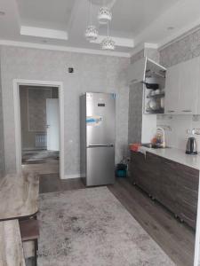 uma cozinha com um frigorífico de aço inoxidável num quarto em ELSAR guesthouse em Osh