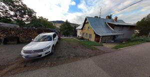 a white car parked in front of a house at Apartmany Dolni Rokytnice nad jizerou čp 37 in Rokytnice nad Jizerou