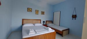 a bedroom with a bed and a small bed and a mirror at Green Forest in Berat