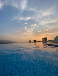a pool of water with the sunset in the background at App. Meeres Blick Eşin Golf Resort in Soke