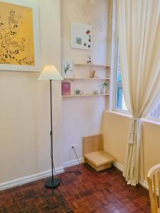 um quarto com um candeeiro de chão e uma janela em DAISY'S STAY em Hanói