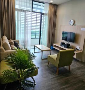 ein Wohnzimmer mit einem Sofa, einem Stuhl und einem TV in der Unterkunft Amy*USS@The Springs Mall in Kuching
