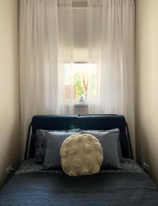 a bed with a pillow in front of a window at Powder Blue Studio in Gdańsk