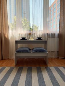 a table sitting in front of a large window at Powder Blue Studio in Gdańsk
