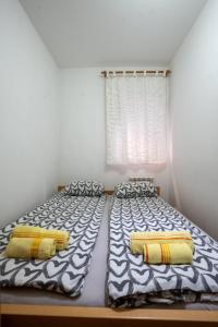a bedroom with two beds and a window at Lorono Kosta in Belgrade