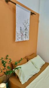 uma cama com uma almofada e uma fotografia na parede em DAISY'S STAY em Hanói