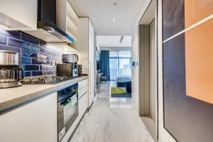 een keuken met witte kasten en blauwe tegels bij Stylish canal view apartment in Business Bay in Dubai