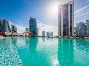 een zwembad van water in een stad met hoge gebouwen bij Stylish canal view apartment in Business Bay in Dubai