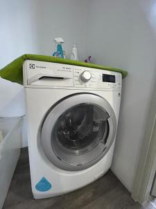 eine Waschmaschine mit einem grünen Handtuch darüber in der Unterkunft Amy*USS@The Springs Mall in Kuching