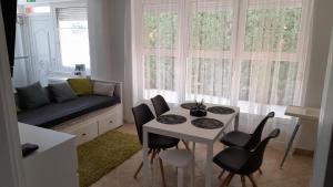 sala de estar con mesa, sillas y sofá en Iza Vendégház, en Hajdúszoboszló
