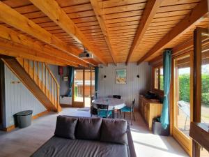 ein Wohnzimmer mit einem Sofa und einem Tisch in der Unterkunft Chalet 6 pers avec piscine in Cabourg