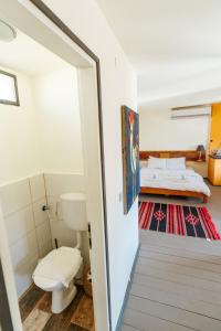 a bathroom with a toilet and a bed in a room at Naot Farm in Mashabbe Sade