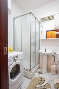 y baño con ducha y lavadora. en Lorono Kosta, en Belgrado