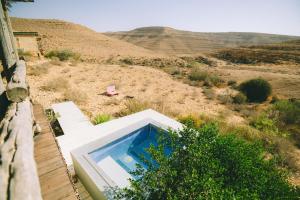a swimming pool in the middle of a field at Naot Farm in Mashabbe Sade
