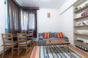 een woonkamer met een bank en een tafel en stoelen bij Cozy Central Condo with Free Dedicated Parking in Sofia