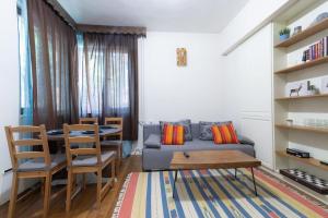 a living room with a couch and a table and chairs at Top Center Relax, NDK & Vitoshka str, FREE Secured parking in Sofia
